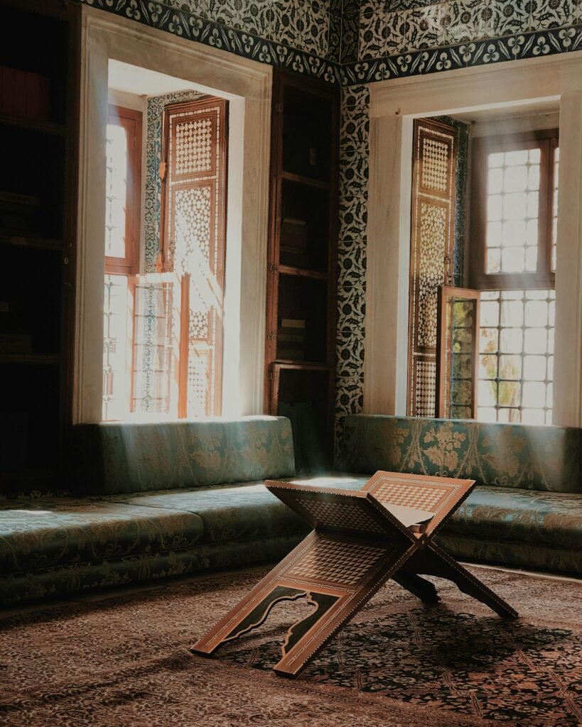 A beautifully decorated Ottoman-style room with sunlight streaming through stained glass windows.